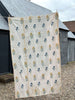 cream coloured indian kantha quilt hangs outside with blue and yellow flower pattern