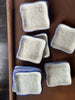 Set of square ceramic dishes with blue rims on a brown surface