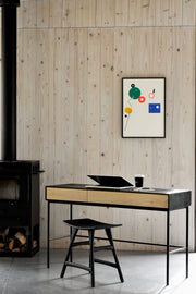 black legged rectangular desk, with natural oak drawers and a black surround that also covers the top.