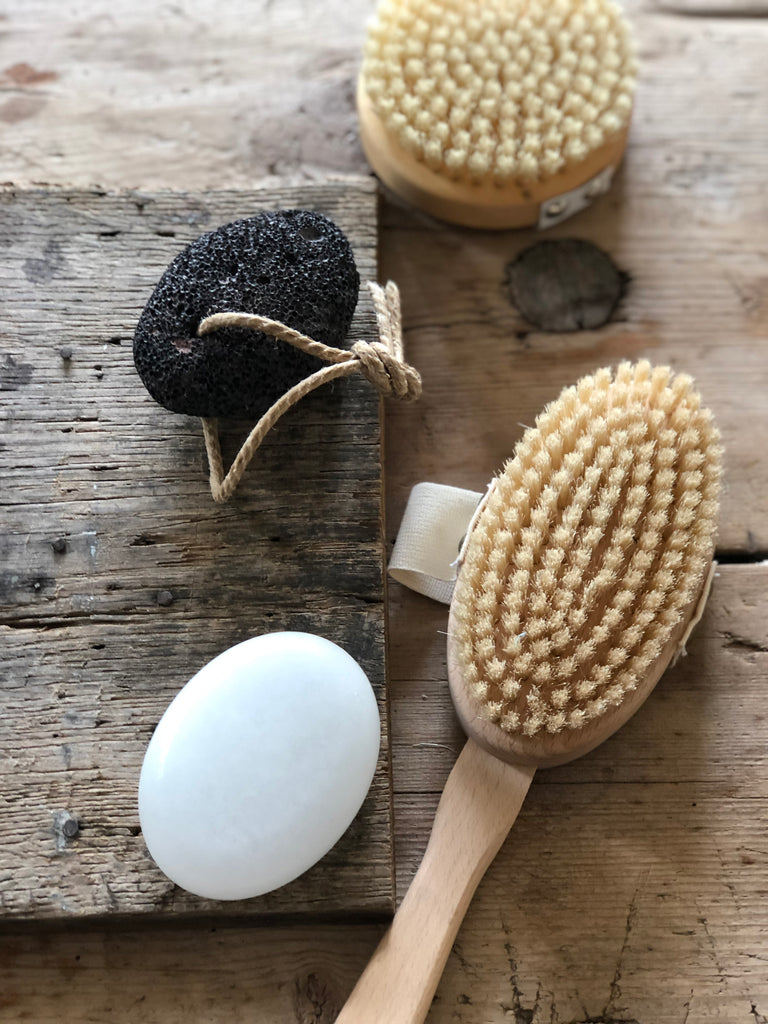 Round, black pumice stone with natural rope hanging loop. Oval back brush with hand loop and long handle. Round body brush with hand loop. Oval shaped, white deoderant stone.