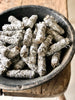 Bundles of dried sage tied with string, displayed in a bowl.